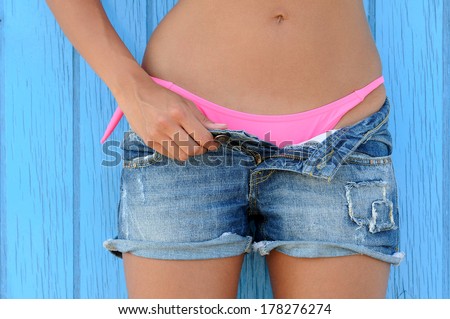 Close up of a woman in jeans texas shorts and pink bikini