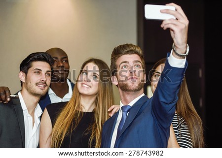 Group of multi-ethnic businesspeople taking a picture themselves with a mobile phone after a business meeting