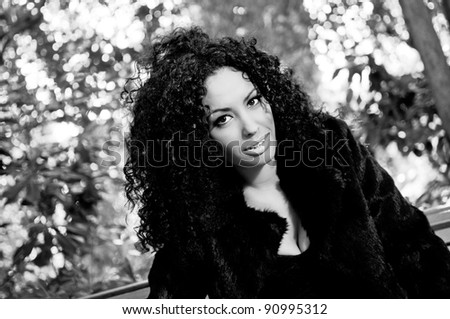 Young black beautiful woman siting on bench in park
