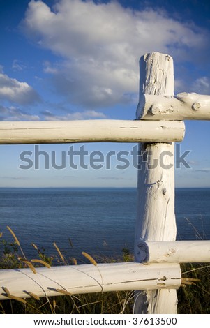 White rustic fence overlooking atlantic ocean shot in PEI, Canada