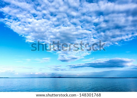 White cumulus clouds over the lake