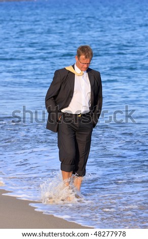 Blond , young businessman walks close to the sea