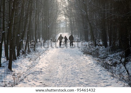 People walking in snowy forest path