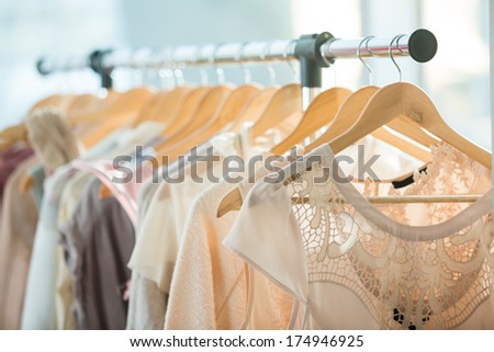 Set of light colored dresses on a wooden hangers