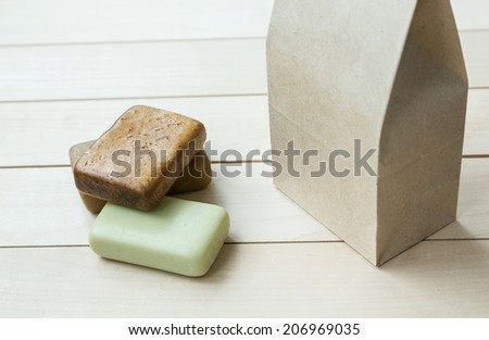 Natural soap bars lying on a wooden background near the craft paper bag