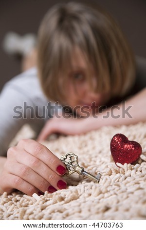 Cute girl holding a key wishing to open someone\'s heart