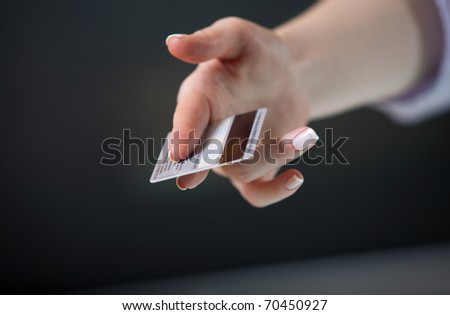 Woman\'s hand stretching out a credit card in offering gesture