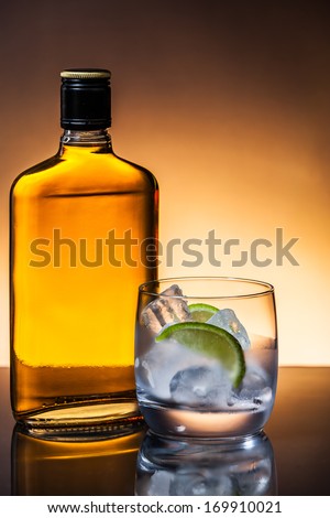 Glass and bottle of hard liquor like scotch, bourbon, whiskey or brandy