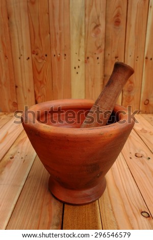Mortar and pestle made of clay and wood.  For processing, depending on the equipment used.
