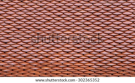 Red tiles roof of a temple in Bangkok, Thailand, architecture background.