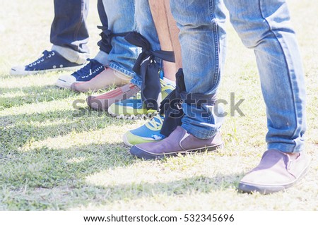 Similar – Image, Stock Photo Three legs in jeans and sneakers, standing on the street in confetti, at carnival.