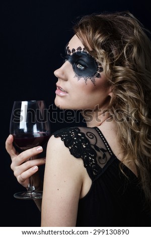 Beauty Girl with a glass of wine.Fashion Art Woman Portrait with fashion mask makeup