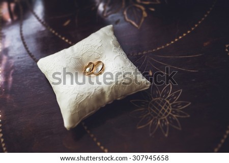 two rings on white pillow