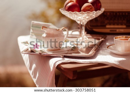 Cup of tea with flowers on table in autumn with fresh flower and towel on table