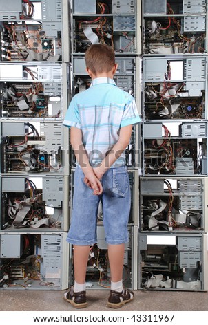 Boy faces to a wall from old computer case. Vertical