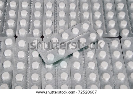 Plenty of white tablets in packing. Silver packs pills. Pills background