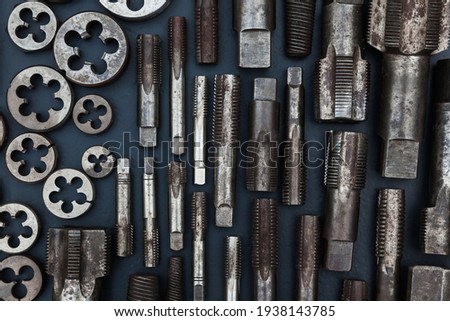 Taps and dies for metal threading. Tools for cutting external and internal threads, close-up.Taps and dies for metal threading. Tools for cutting external and internal threads, close-up.