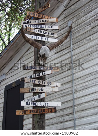 Signs pointing the directions to various cities on a pole just outside the old Cut-Rite chain saw building used in Texas Chain Saw Massacre 2.