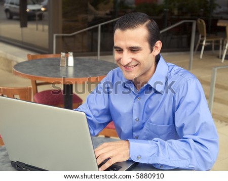 Handsome hispanic businessman surfing the internet on a laptop.