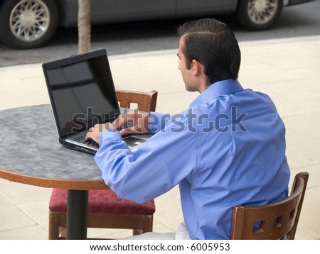 Handsome hispanic businessman surfing the internet on a laptop.