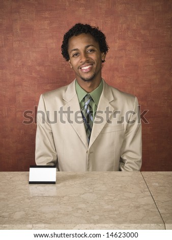 A hotel employee cheerfully welcomes guests.