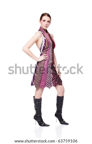 full length studio shot of a woman in a dress made of neckties looking at the camera while posing.