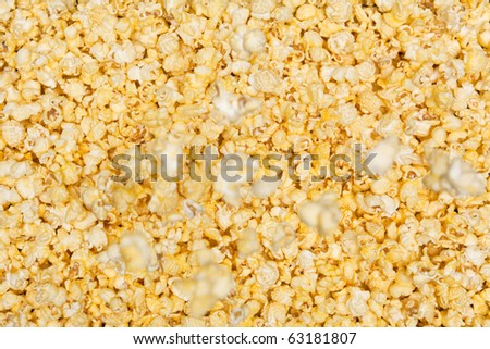 Yellow movie style popcorn background with individual popcorn falling down from above.