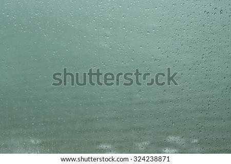 Rain drops on window (sea background)