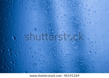 Abstract background with water drops on window glass and metallic blue shining