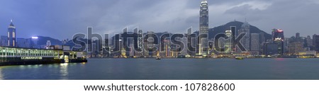 panoramic view of the Hong Kong skyline at evening. On the left side the Tsim Sha Tsui Ferry pier