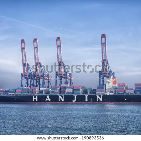 ROTTERDAM - MARCH 8, 2014: Hanjin container ship being unloaded in the Rotterdam harbor. Hanjin is the seventh largest container transportation and shipping company in the world