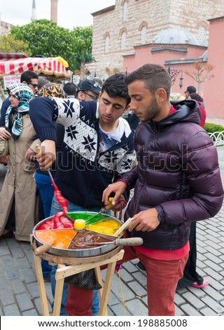 ISTANBUL - APRIL 26, 2014: Unknown vendors preparing multi-colored caramel on a stick. It is a traditional delicacy mostly sold in front of the main tourist attractions