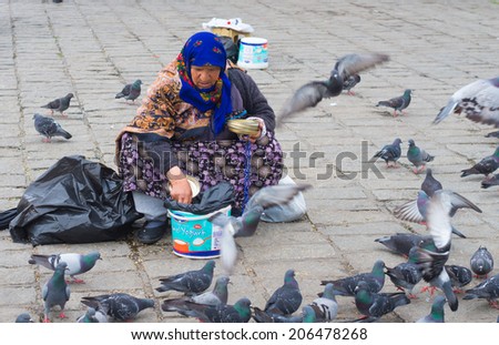 ISTANBUL - APRIL 30, 2014: Old unknown turkish woman in istanbul is selling pigeon food for a living