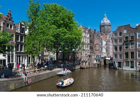 AMSTERDAM - MAY 18, 2014: Unknown people in a boat on an amsterdam canal. Amsterdam counts 165 canals with a total length of 100 km.