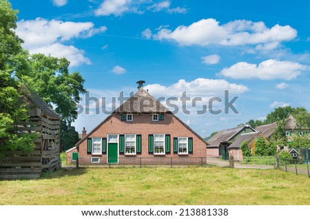STAPHORST, NETHERLANDS - MAY 31, 2014: Typically dutch farmhouse with green blinds. The community of Staphorst is known as one of the most religious in the Netherlands and has a very closed character.