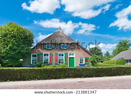 STAPHORST, NETHERLANDS - MAY 31, 2014: Typically dutch farmhouse with green blinds. The community of Staphorst is known as one of the most religious in the Netherlands and has a very closed character.