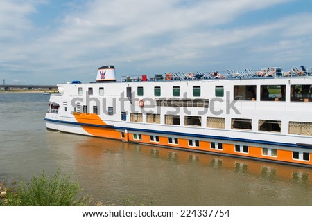 NIJMEGEN, NETHERLANDS - JULY 20, 2014: German river cruise ship with relaxing people on its deck moored at the Waal quay.