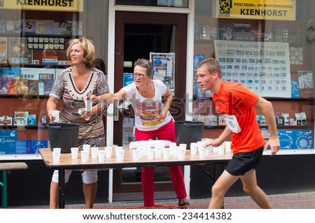 OLDENZAAL, NETHERLANDS - AUGUST 10, 2014: Unknown people at a refreshment point at the \