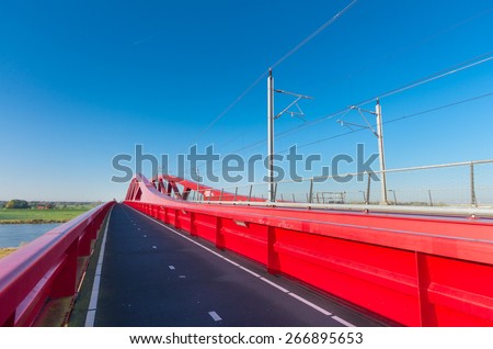 bicycle lane along the new red railroad bridge over the IJssel river in the Netherlands