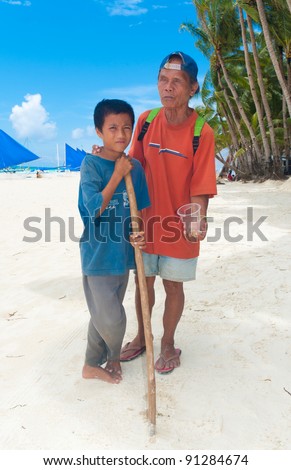 BORACAY ISLAND, PHILIPPINES - SEPTEMBER 05: Blind beggar with son ask for money on September 05, 2011 on Boracay, Philippines. According UNICEF 2011 statistics 43% of the population live in poverty (under $2/day).
