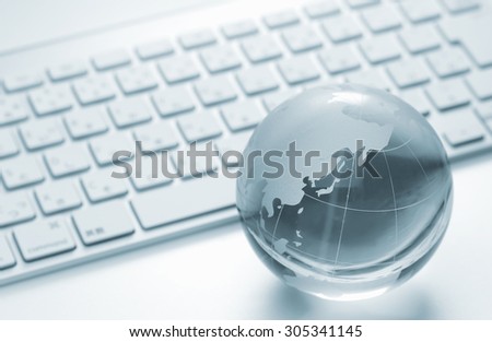 Glass globe and the keyboard - world business and economy