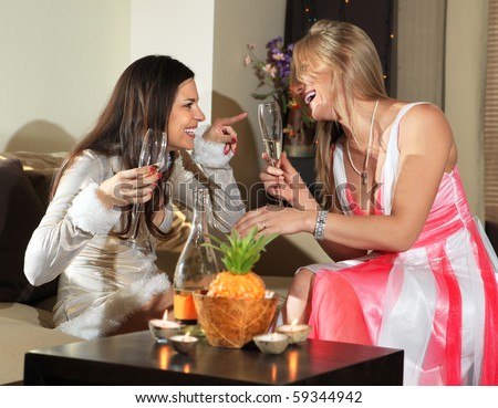 Happy women with glasses of wine talk about in drawing room