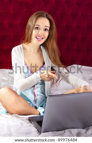 emotional young happy woman on the bed points out on laptop