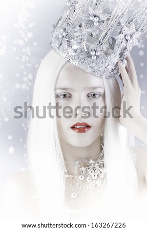 young woman with crown is on a snow background