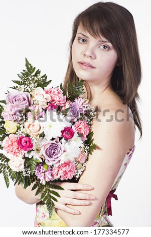 smiling caucasian young woman with bouquet of different flowers on a white background