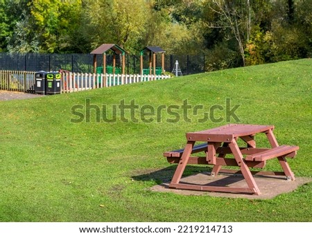 Wooden picnic bench with children's playground in the background. Foto stock © 