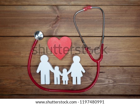 Health care and insurance concept. Family medicine. Icon of family, red heart and stethoscope on wooden background. Life insurance for whole family. 商業照片 © 