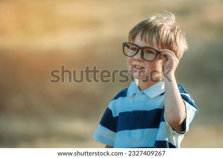 Similar – Image, Stock Photo Boy wearing glasses and looking at a display of a mobile under the supervision of an adult