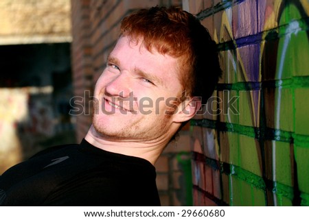 The smiling man near wall with graffiti