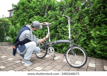 Similar – Image, Stock Photo Repairman fixing bicycle wheel in workshop